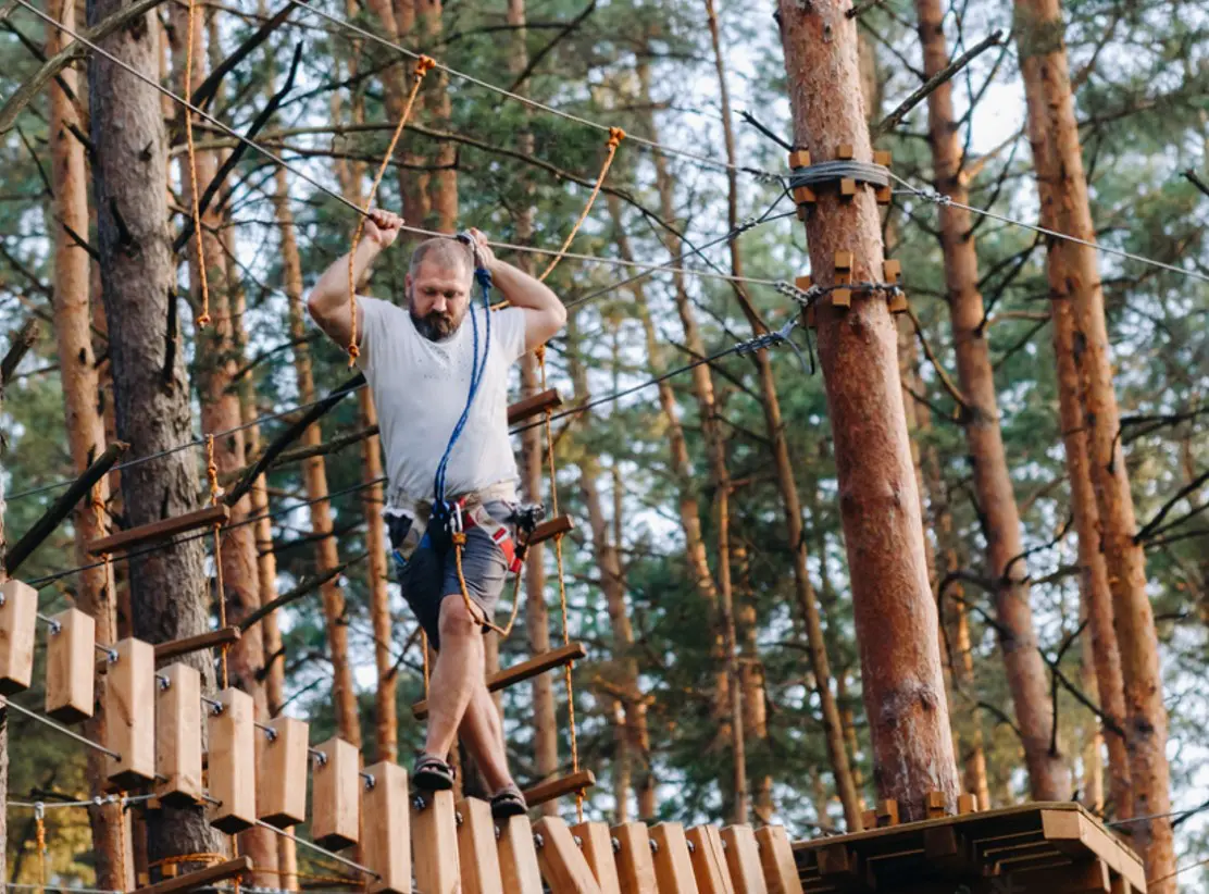 Adobe Stock_man struggling on ropes course